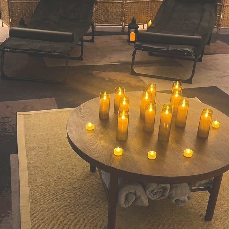 Candlelit lounge with reclining loungers and a woven privacy screen